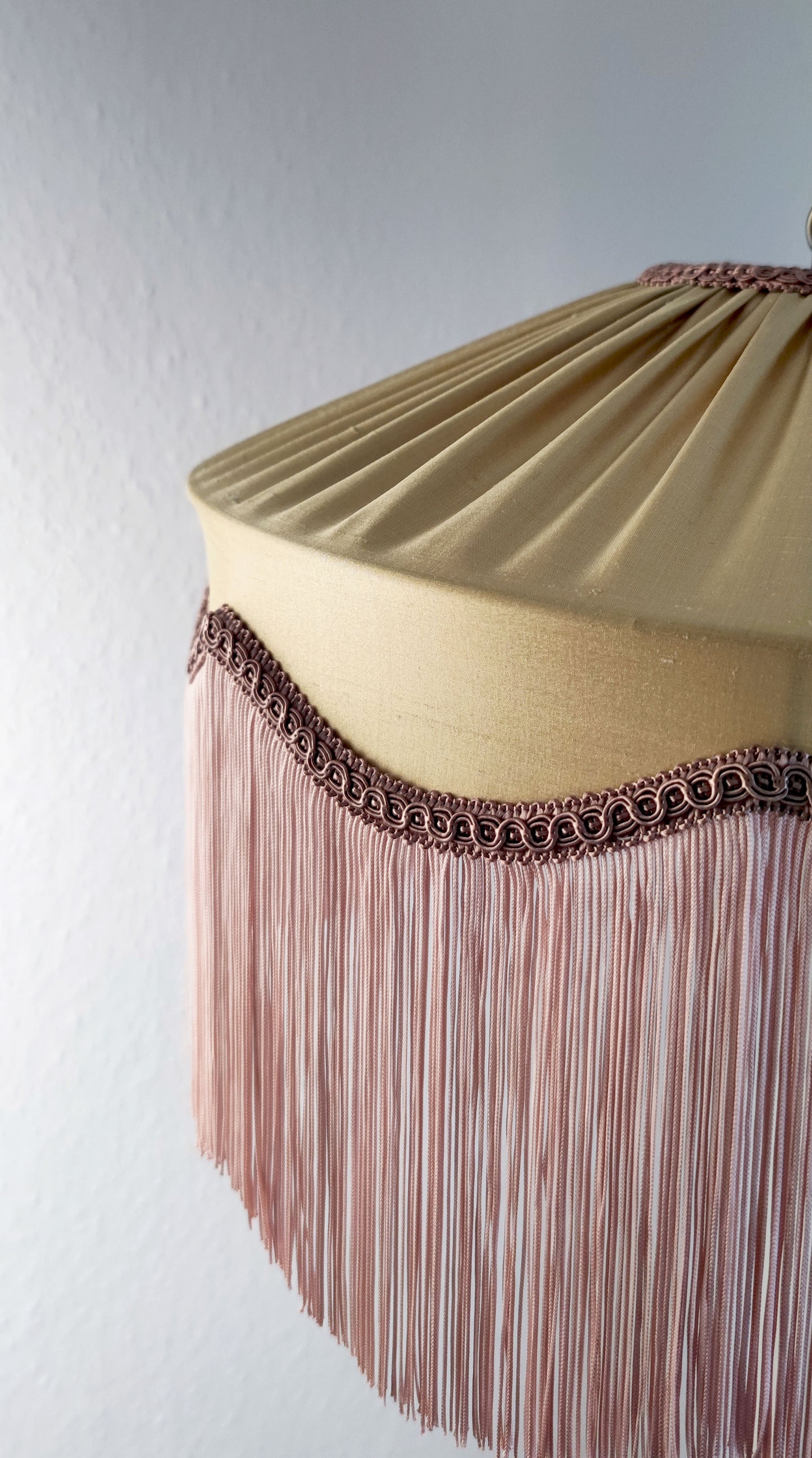 Gold silk fringed lampshade with blush fringe and decorative trim, ideal for vintage or Art Deco-inspired interior lighting designs.