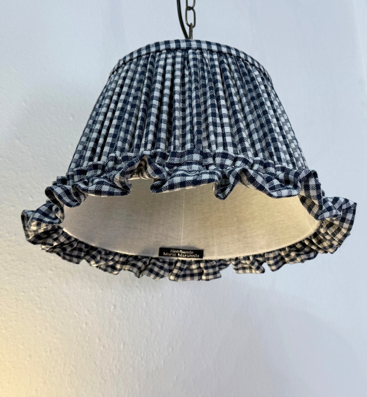 Checkered lampshade with ruffles on a plain background