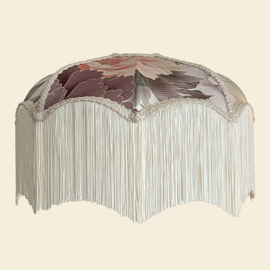 Decorative lamp with floral design and fringe on a beige background. The House of Soft Light