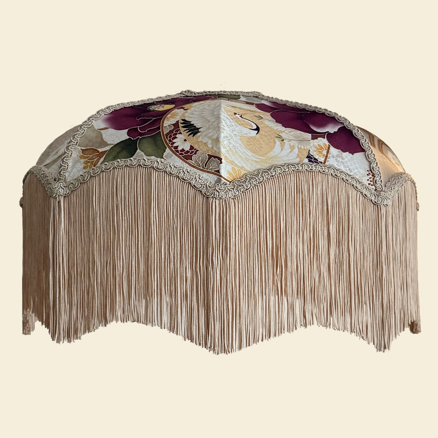 Decorative lampshade with floral patterns and fringe on a beige background. The House of Soft Light