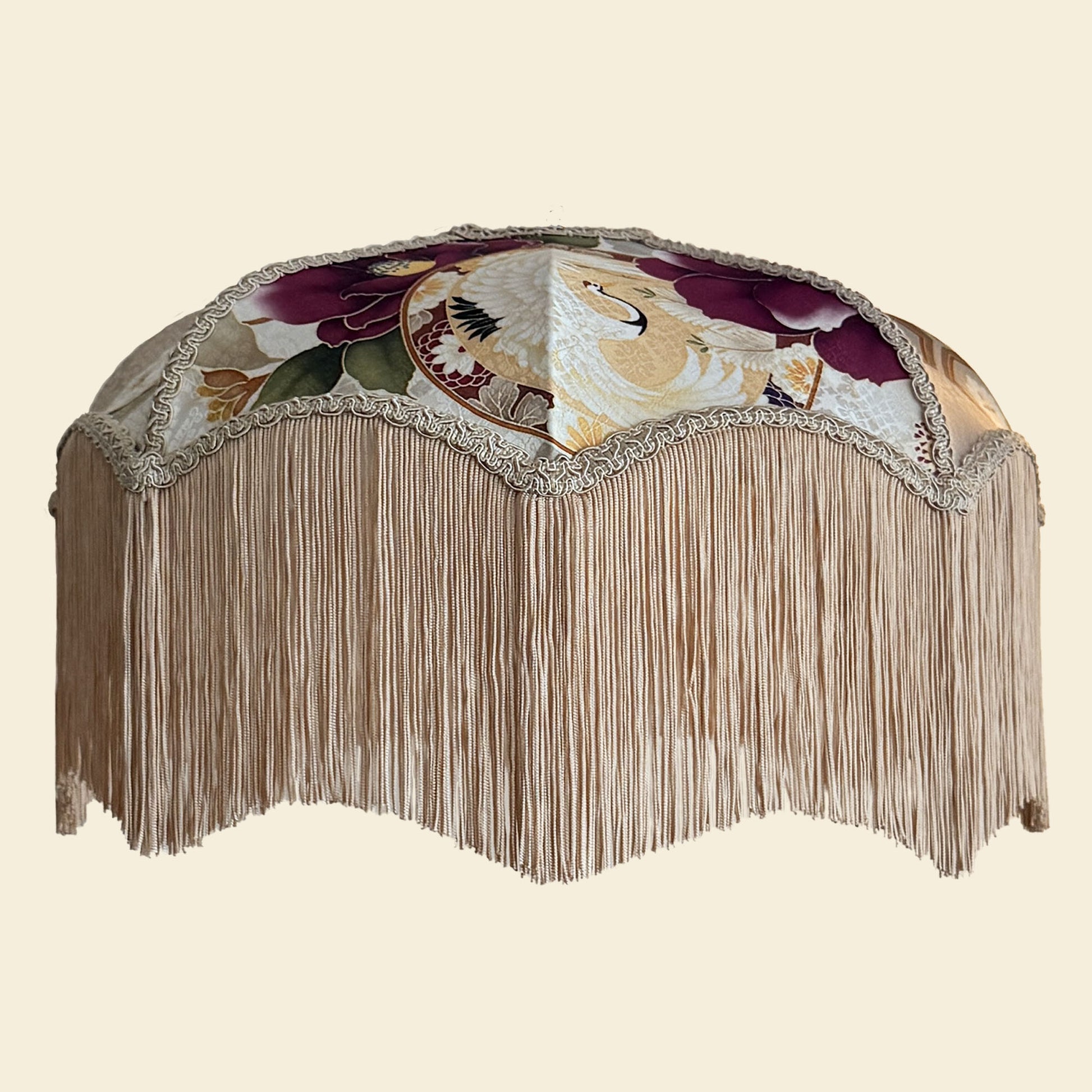 Decorative lampshade with floral patterns and fringe on a beige background. The House of Soft Light