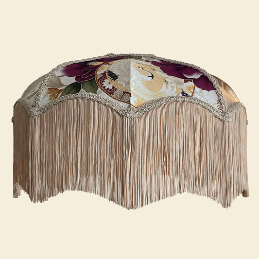 Decorative lampshade with floral patterns and fringe on a beige background. The House of Soft Light