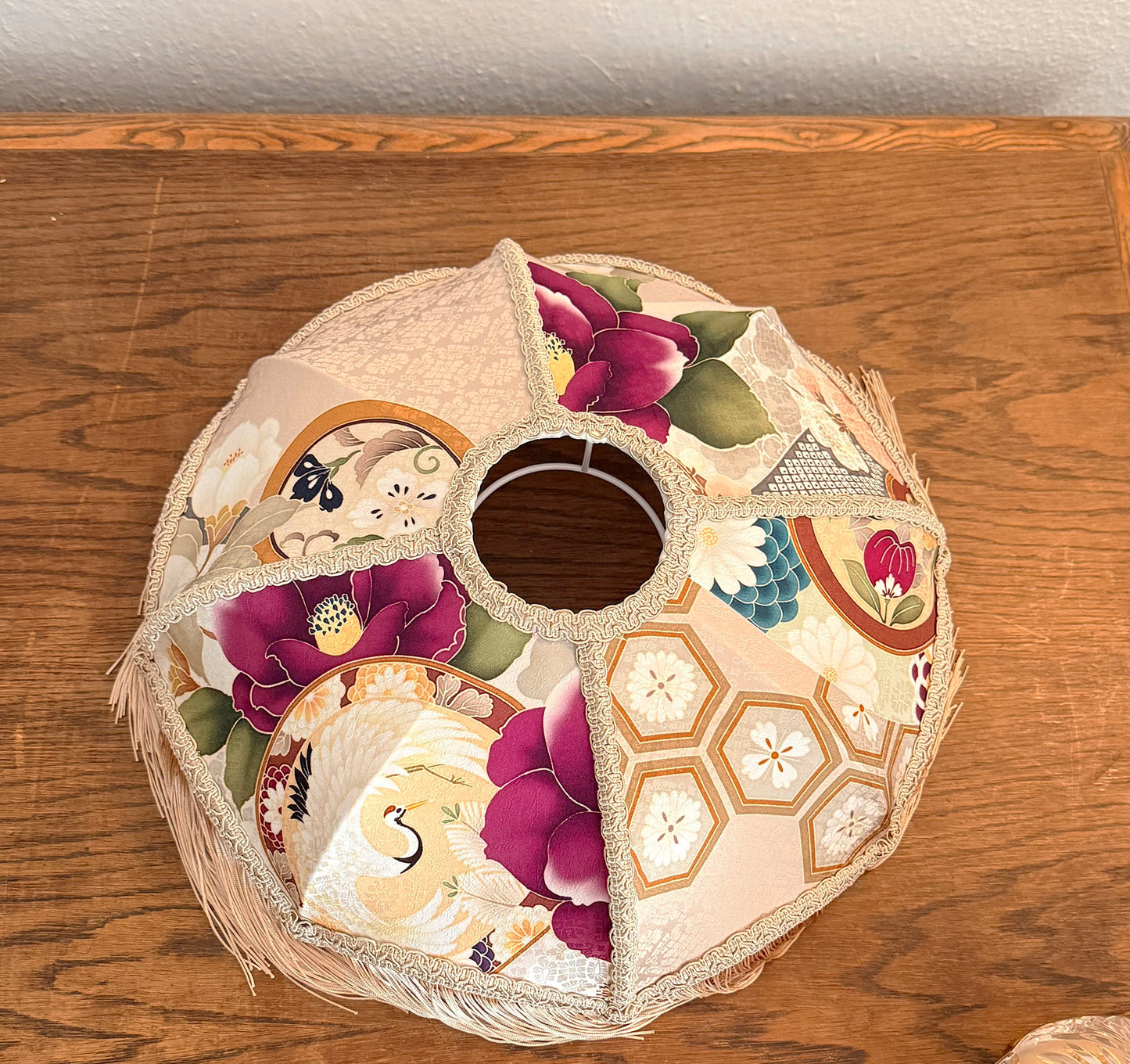 Decorative lampshade with floral patterns on a wooden surface