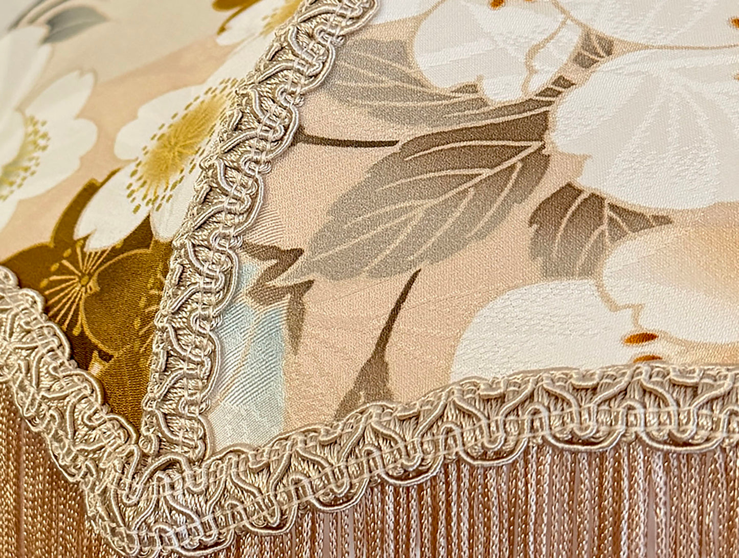 Close-up of floral fabric with lace trim lampshade on a beige background The House of Soft Light