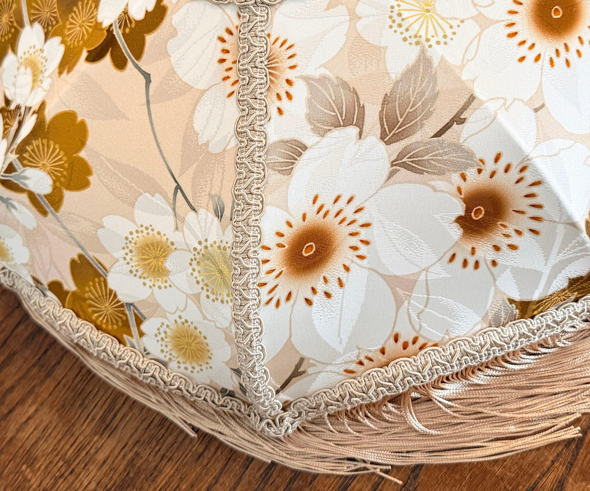 Close-up of a floral-patterned fabric with white and brown flowers lampshade on a wooden surface The House of Soft Light