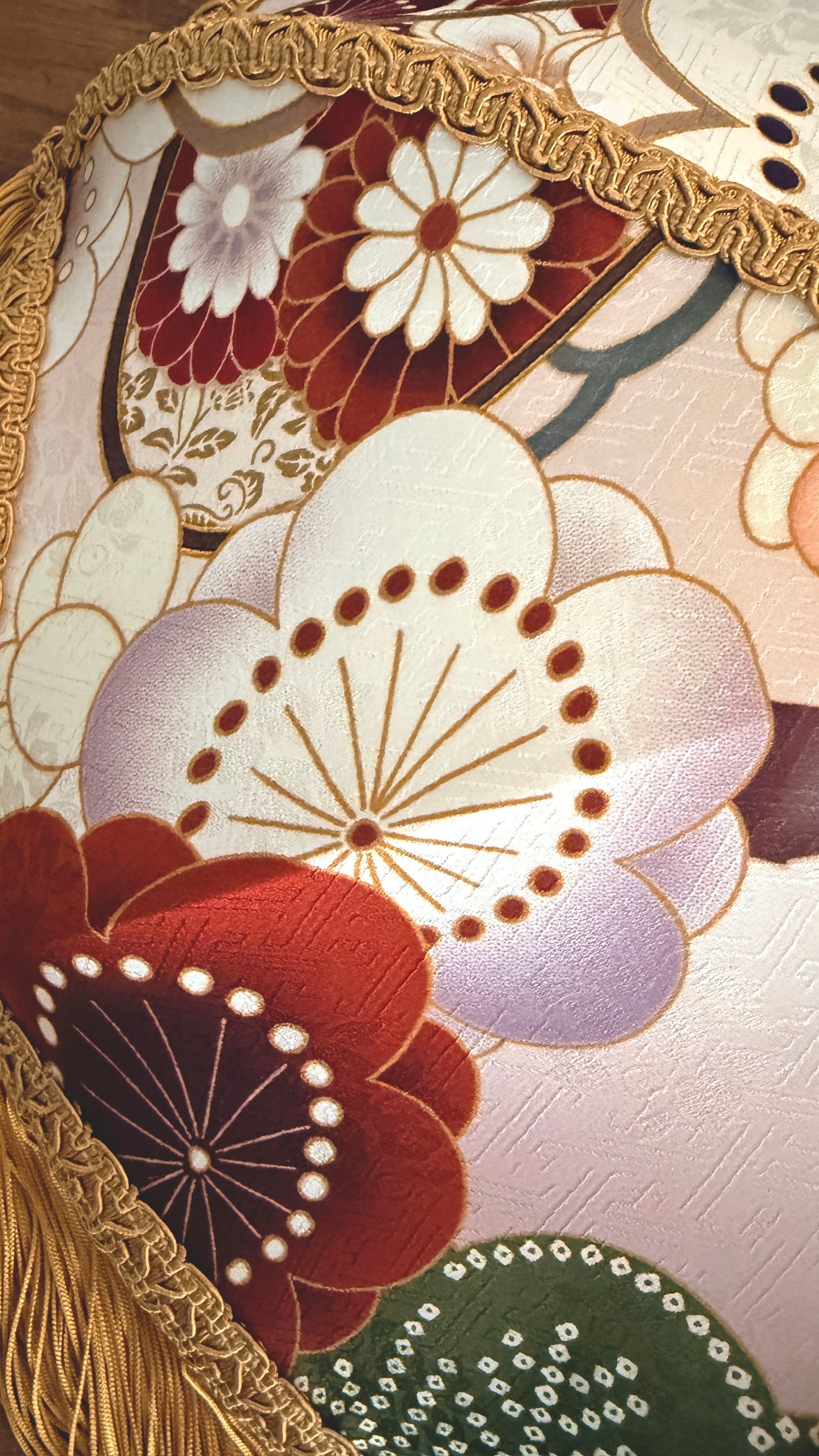 Close-up of a decorative fabric with floral patterns and gold accents