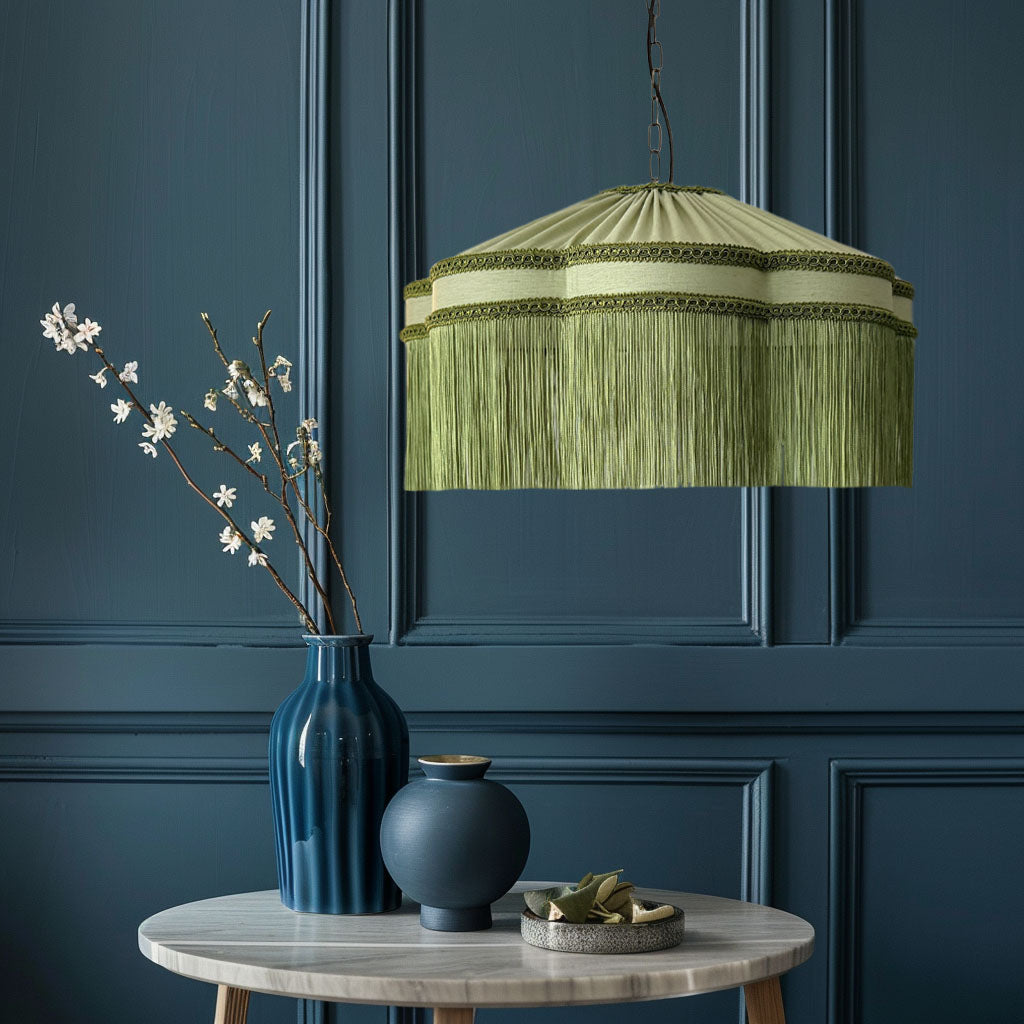 Green pendant lamp hanging above a table with decorative items against a dark blue paneled wall.