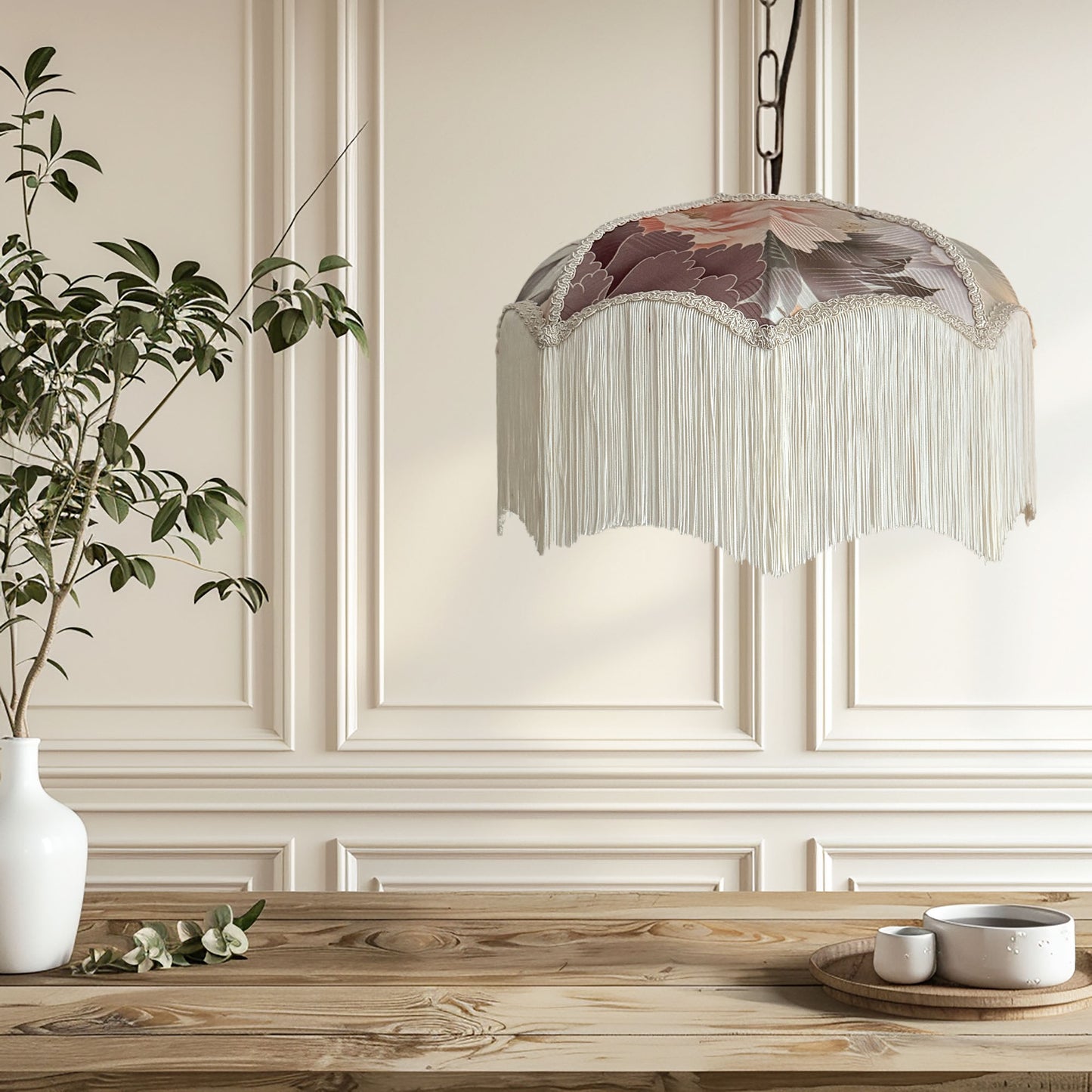 Decorative pendant light with floral design hanging above a wooden table.