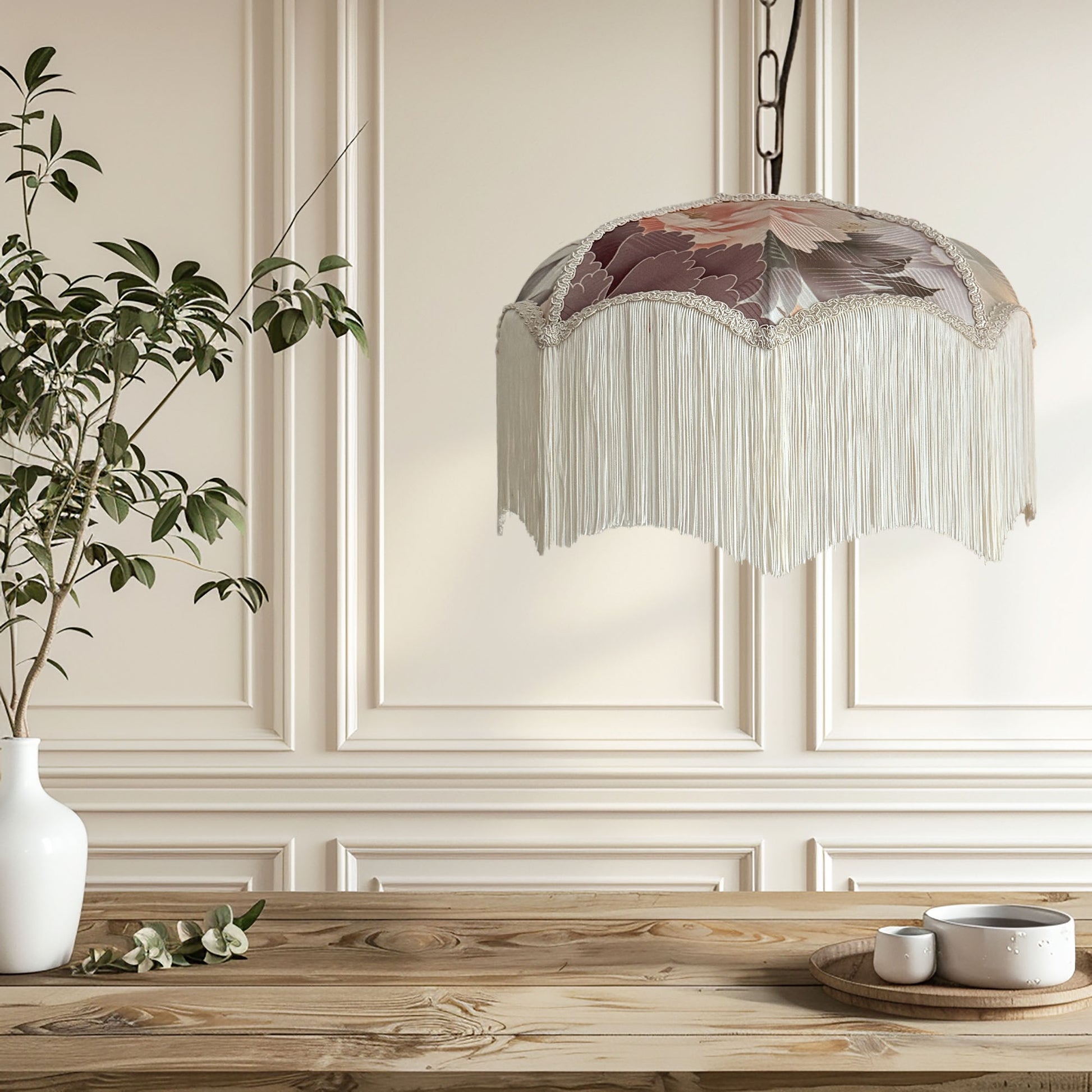 Decorative pendant light with floral design hanging above a wooden table.