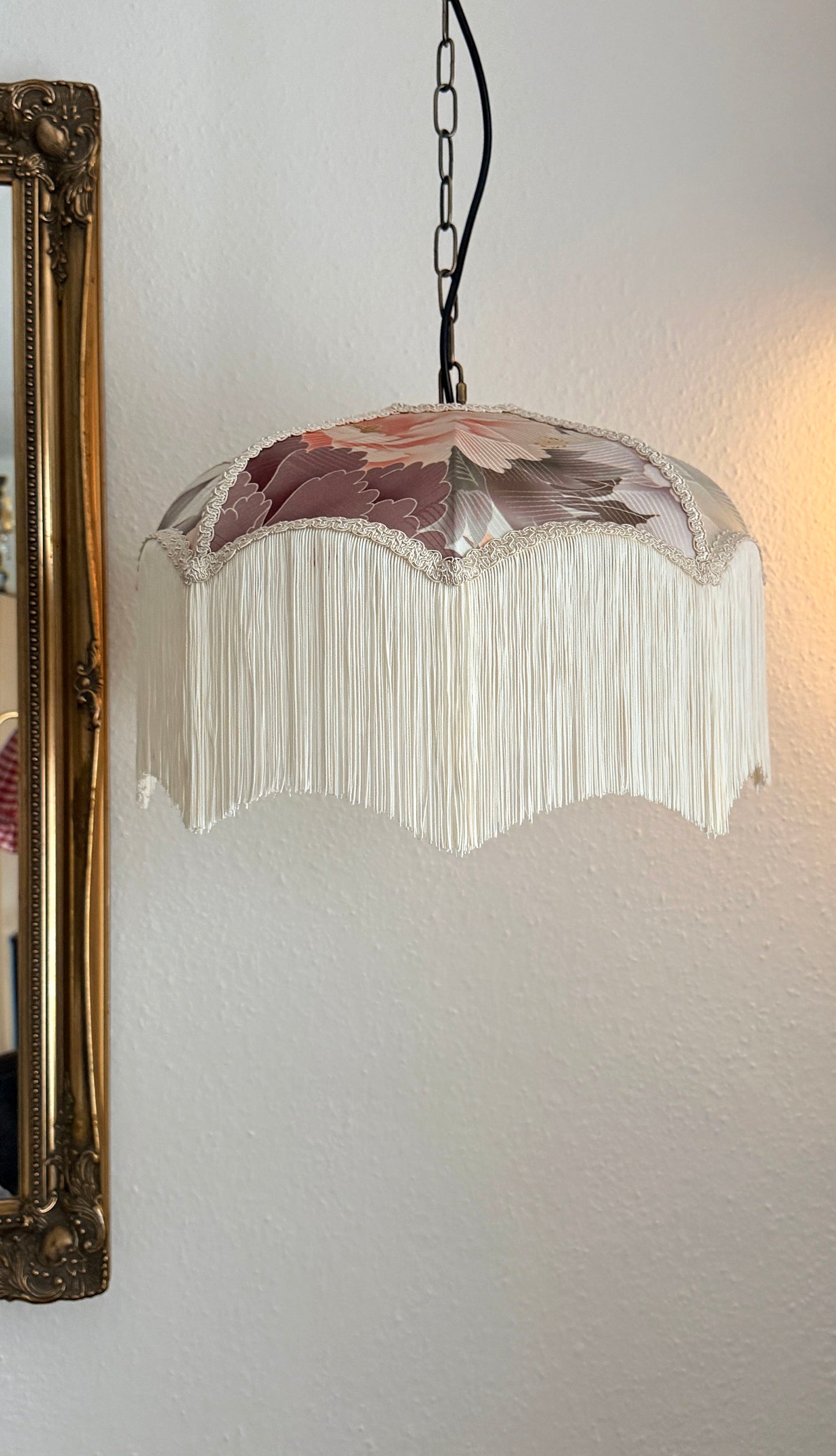 Decorative pendant light with floral design on a white wall. The House of Soft Light