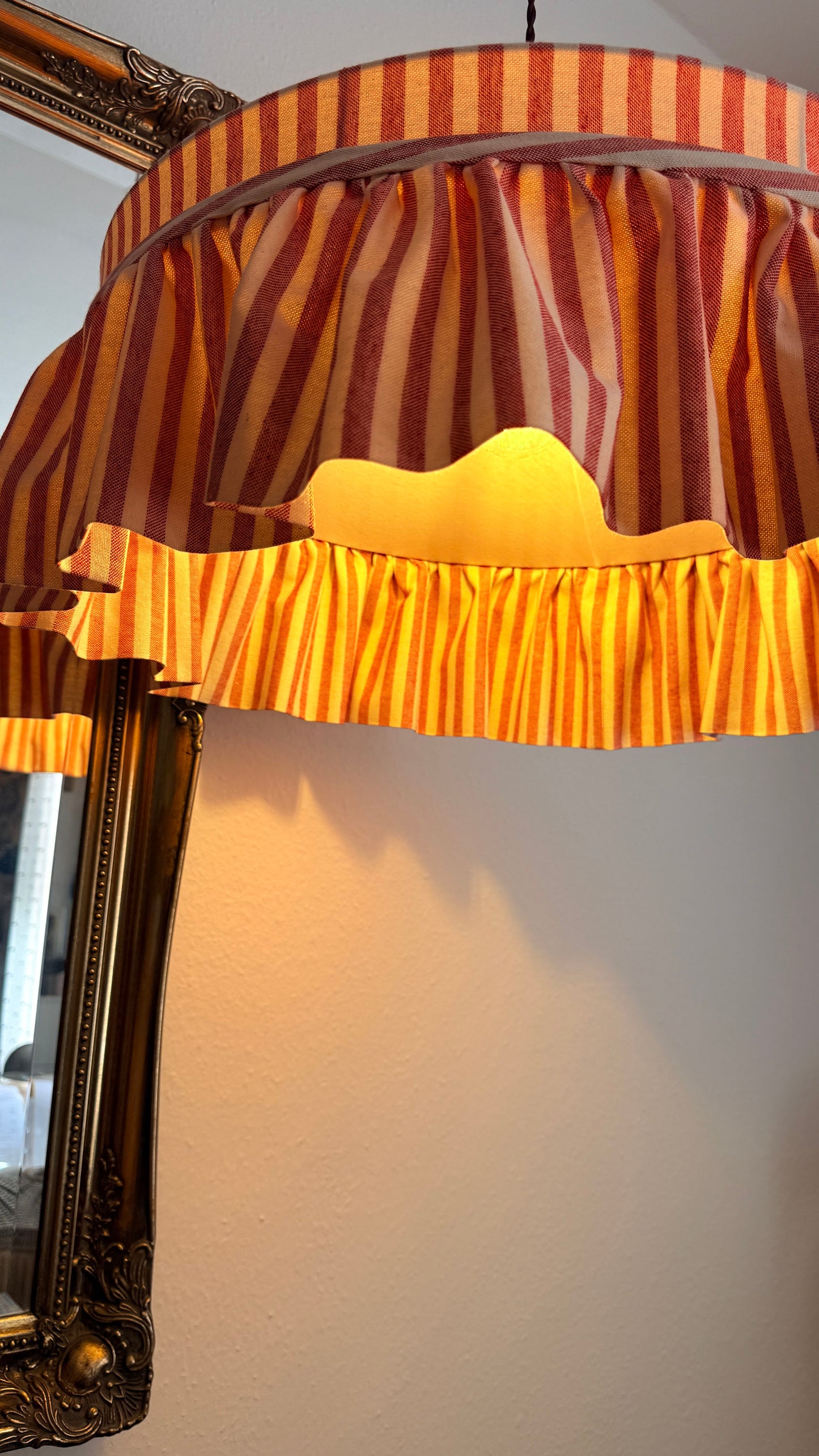 Striped lampshade with a textured surface on a white wall.