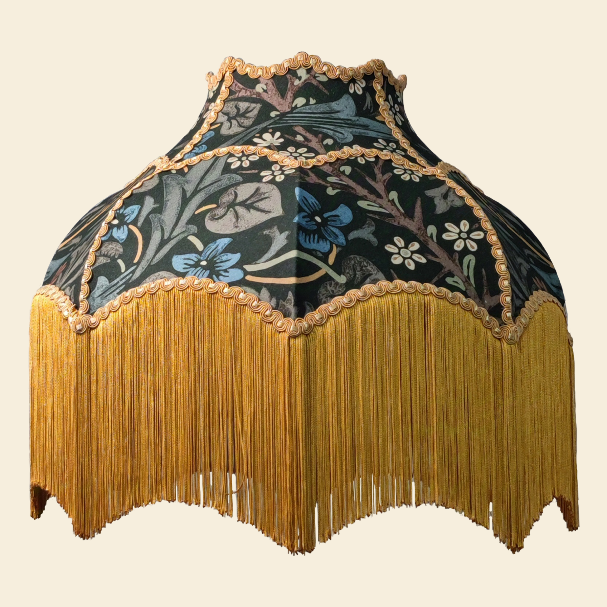 Decorative lampshade with floral pattern and gold fringe on a beige background