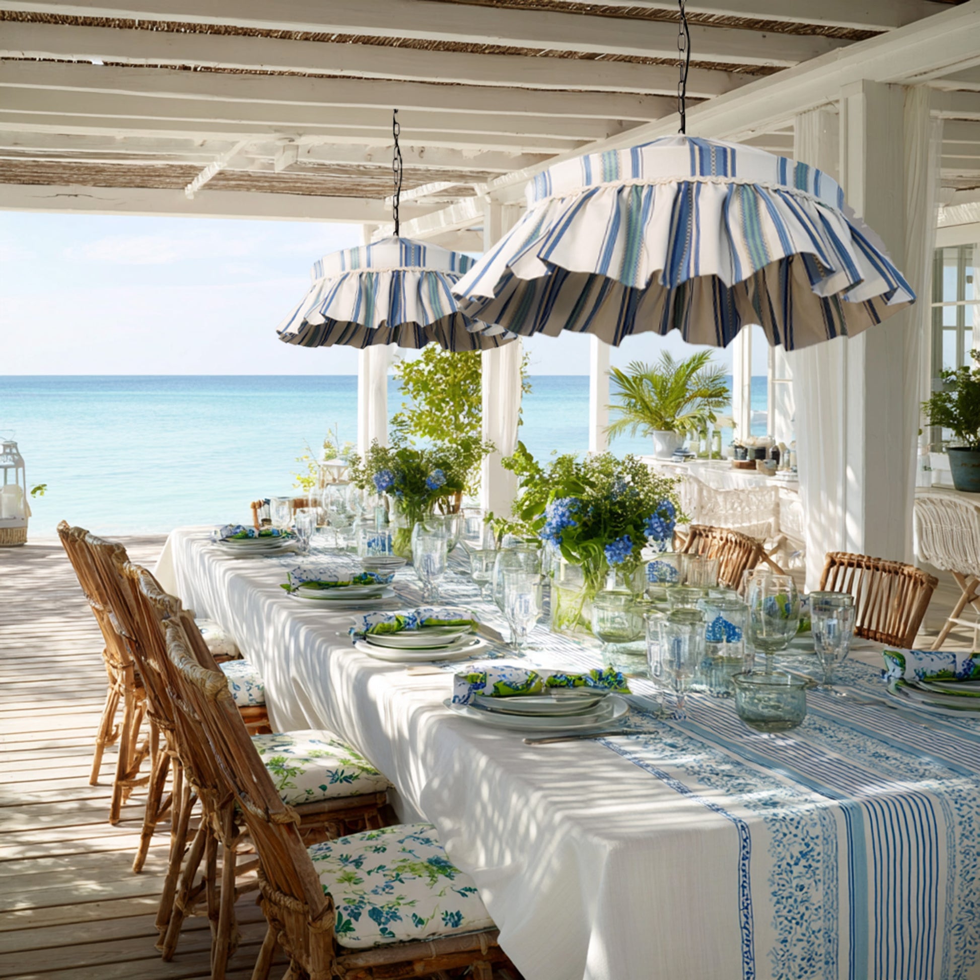 Sanderson ruffle handsewn cotton lampshade in blue stripes hanging over a coastal dining table with rustic decor and floral accents.