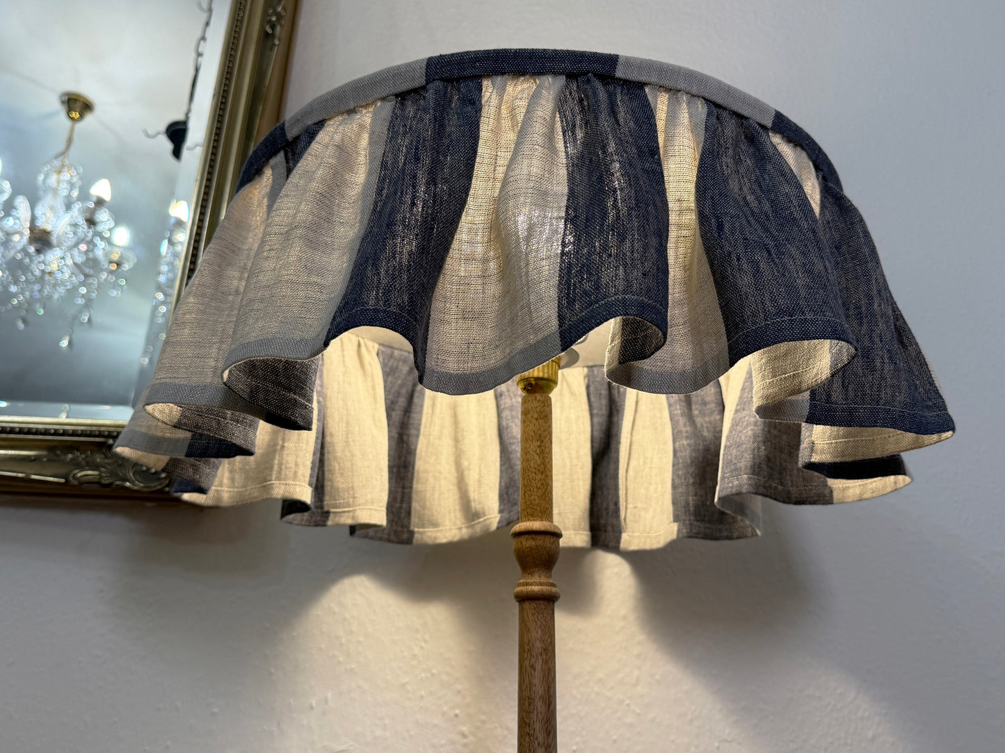 Decorative lamp with a layered fabric shade on a plain background