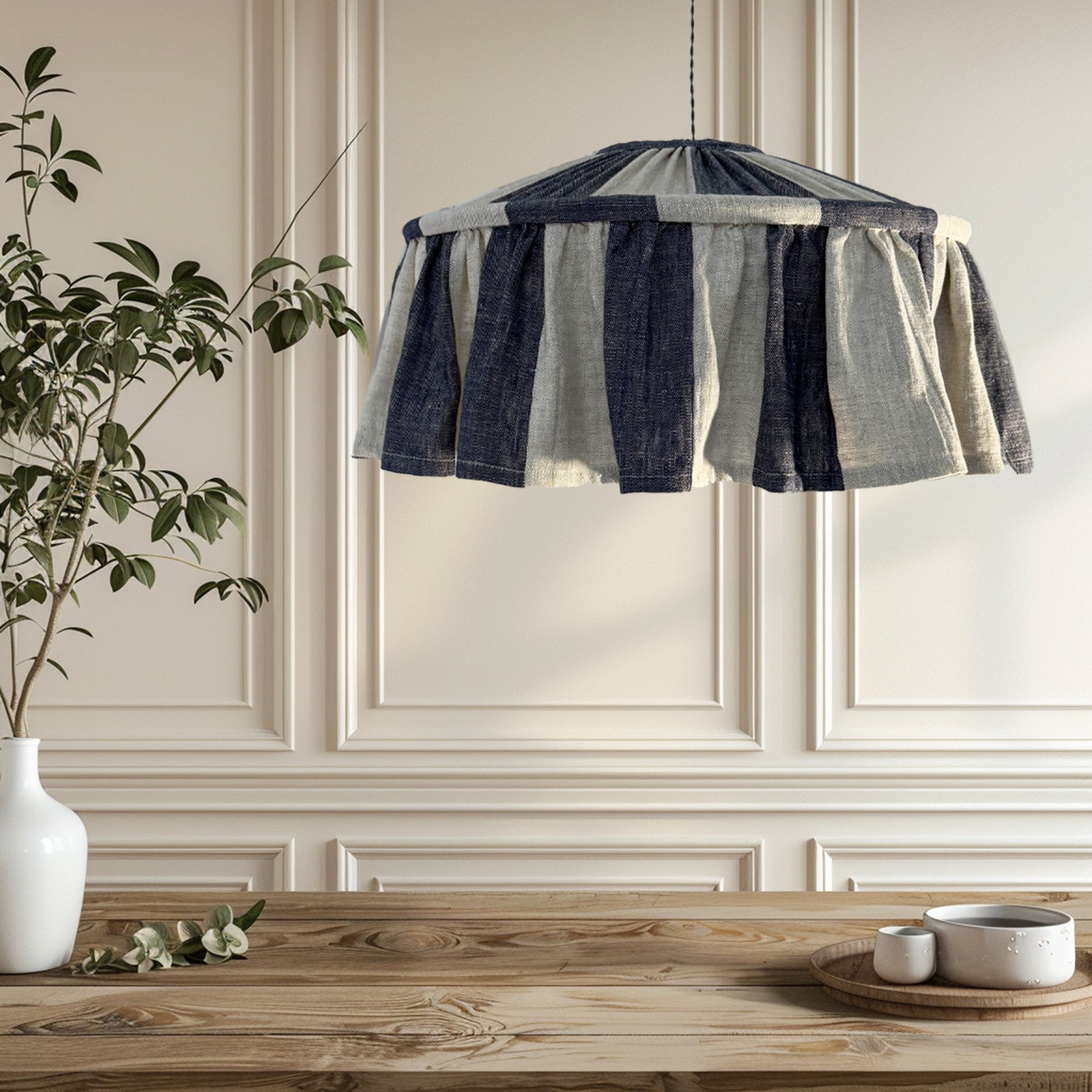 Indigo-patterned lampshade hanging above a wooden table with decorative items