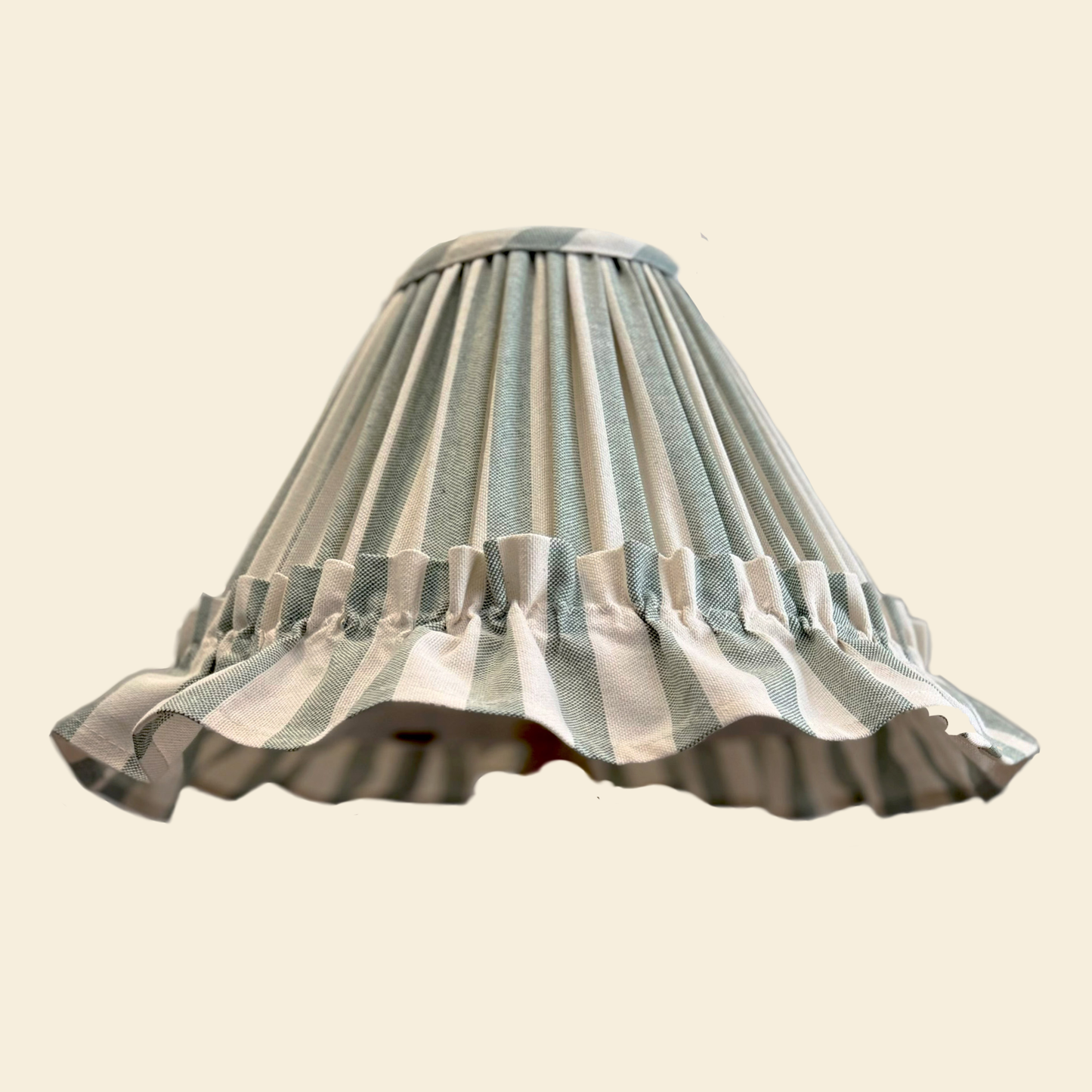 Striped mint green lampshade with ruffled edge on a beige background