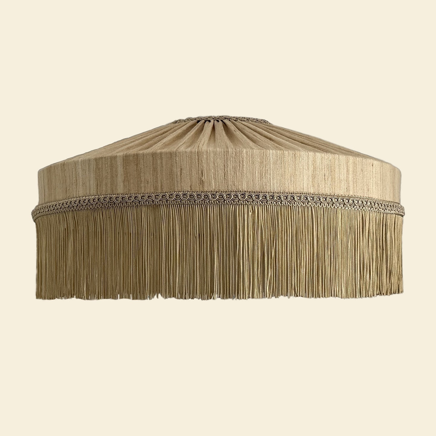 Beige lampshade with fringes on a beige background