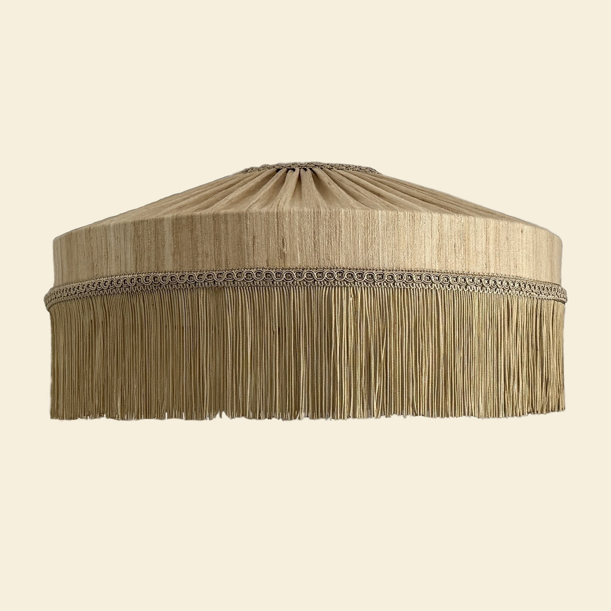 Beige lampshade with fringes on a beige background
