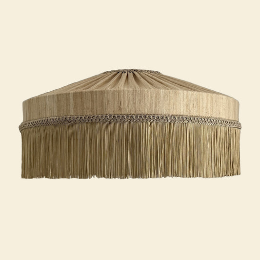 Beige lampshade with fringes on a beige background