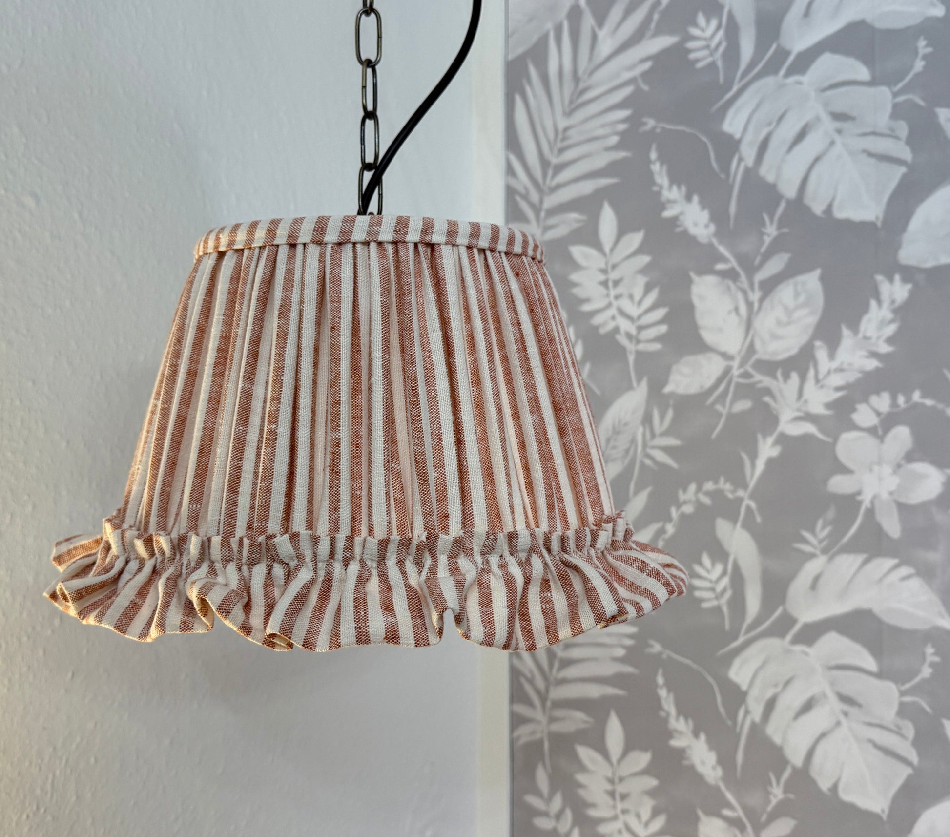 Striped lampshade with ruffled edge on a plain background