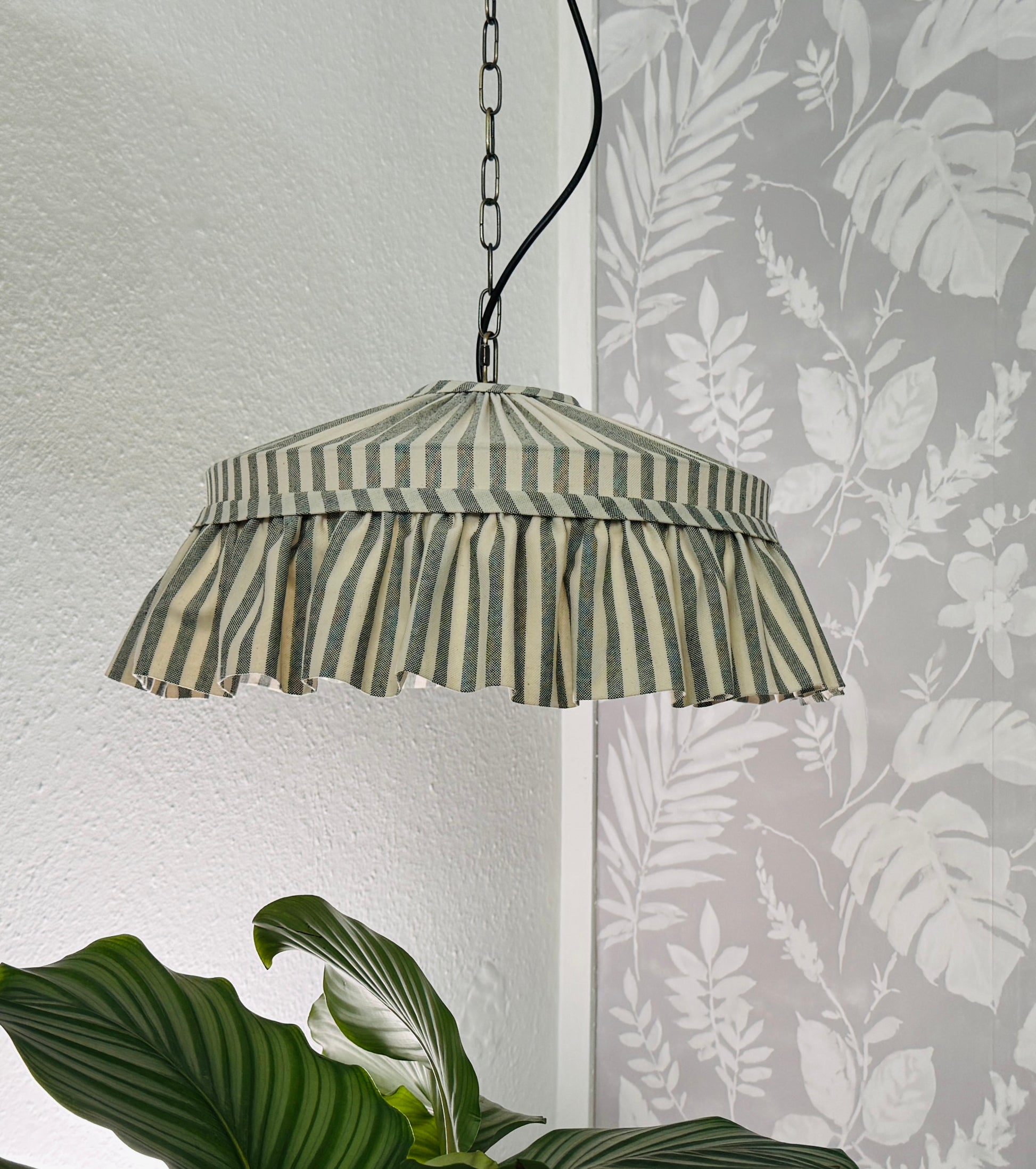Striped pendant lamp hanging against a wall 