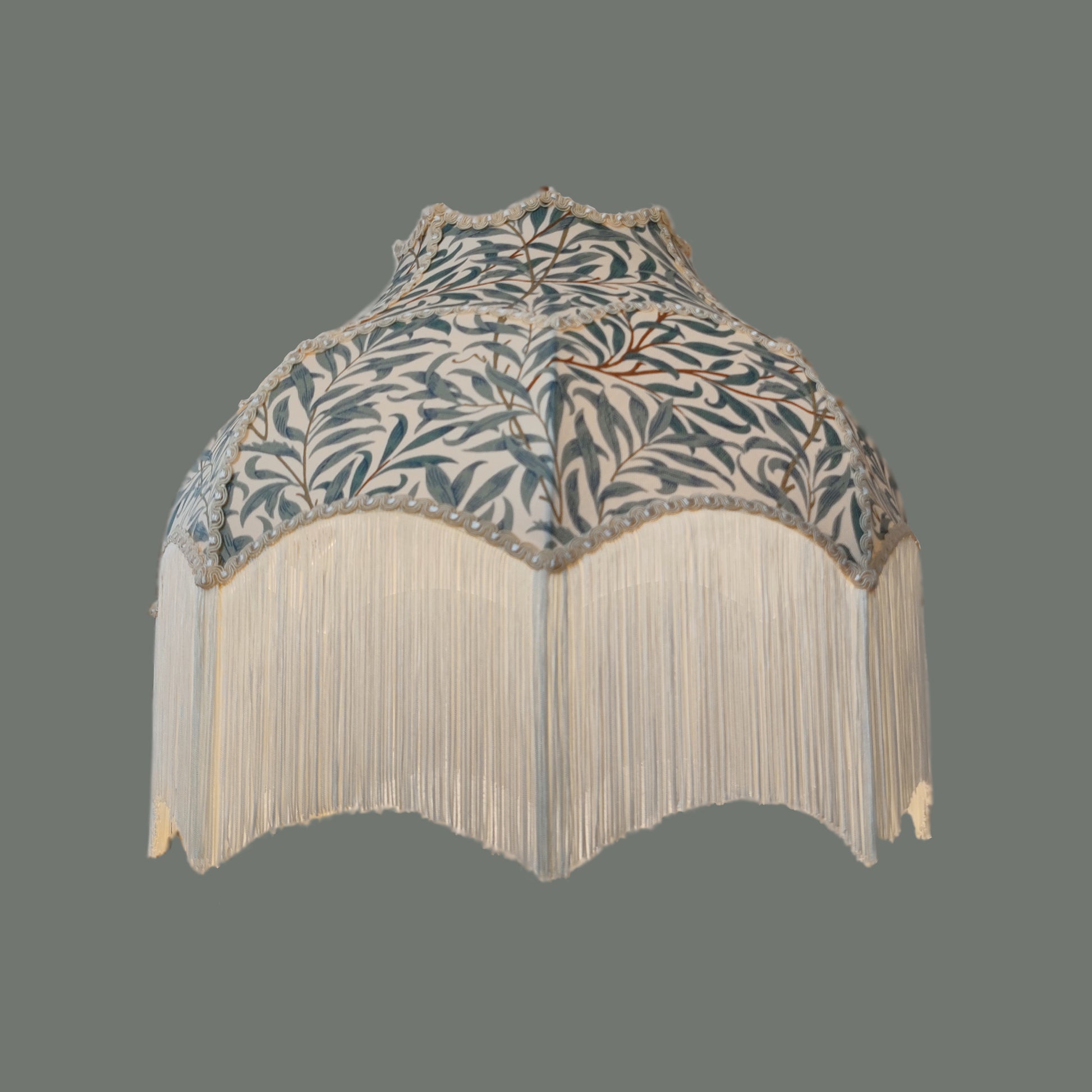 Decorative lampshade with William Morris Willow Bough leaf pattern and fringe on a gray background